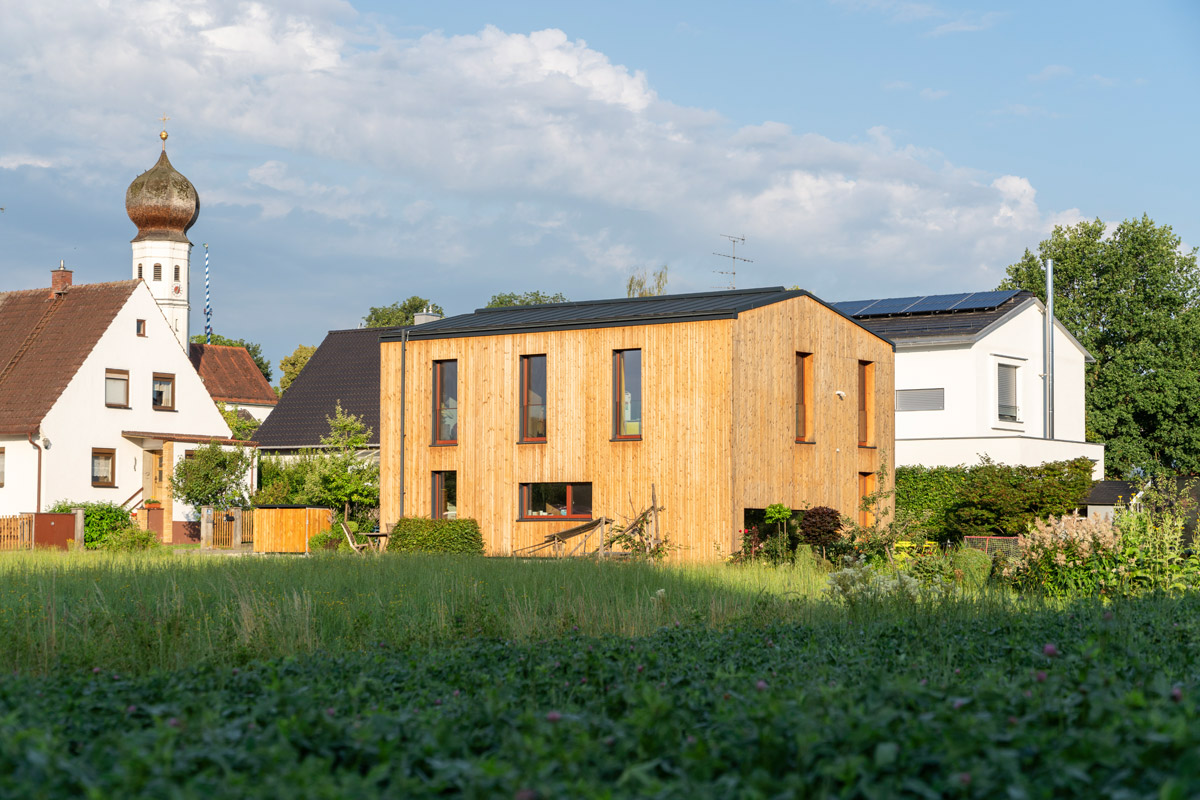 Holzbau Haus am Bach: Das Einfamilienhaus fügt sich perfekt in die ländliche Umgebung ein.