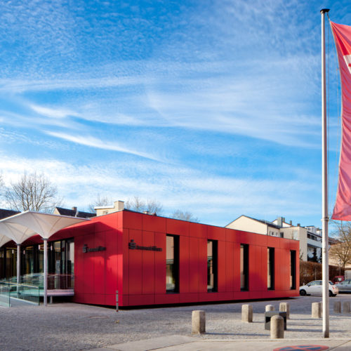 Holzbau Immobilien-Pavillon: Einstöckig fasst das Gebäude den Platz in Richtung Westen räumlich ein.