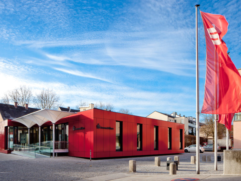 Holzbau Immobilien-Pavillon: Einstöckig fasst das Gebäude den Platz in Richtung Westen räumlich ein.