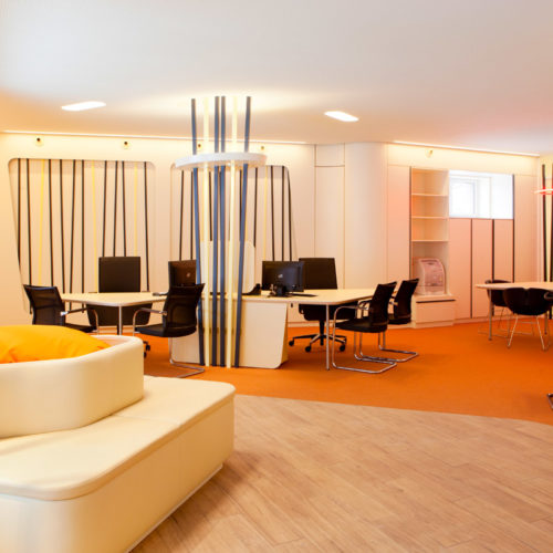 Ladenbau für ein Reisebüro: Der Kunde steht oder sitzt im Mittelpunkt um Beratungsinseln.