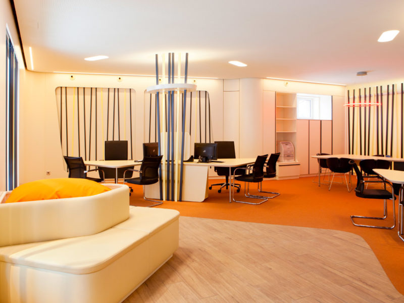 Ladenbau für ein Reisebüro: Der Kunde steht oder sitzt im Mittelpunkt um Beratungsinseln.