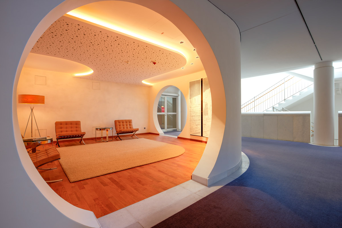 Lounge im Bankhaus - zwei große runde Öffnungen erschließen Flur und Wartebereich